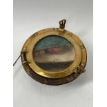 A vintage brass framed porthole, illuminated. COLLECTORS ELECTRICAL ITEM: REWIRING REQUIRED