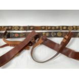 Two Sam Browne leather belts together with two further belts with applied military badges