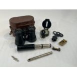 A pair of wartime binoculars, a field compass, multi-lens magnifying glass, silk cigarette cards and