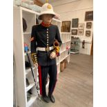 A Royal Marine Uniform upon a male mannequin, together with helmet, bugle and staff