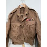 A 1949 pattern battledress blouse, size 11, dated 1954, Royal Artillery insignia and WWII medal