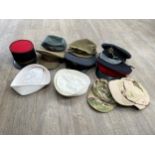 A box of mixed headwear including King's crown peaked cap, mid Century kepi and RAF