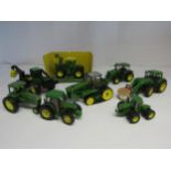 A collection of unboxed diecast John Deere farm vehicles including Britains ERTL, Siku etc (8)