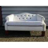 A teddy bear sofa in white button back upholstery, raised on fluted legs, originally purchased at