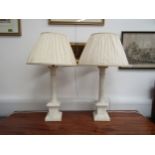A pair of carved marble form column table lamps with pleated silk shades, 62cm tall