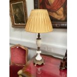 An ornate brass and marble table lamp with silk pleated shade