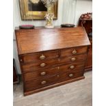 A George III mahogany bureau, crossbanded fall front opening to reveal a fitted interior, over two