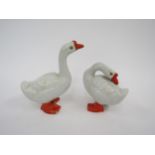 A pair of Chinese enamelled geese, one a/f, 18.5cm and 13.5cm tall