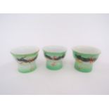 Three Japanese sake cups with magnifying lens to base revealing erotic images of male and females