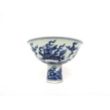 A Chinese blue and white stem cup with winged dragon and waves, six character marks within base,