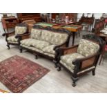 A mahogany carved frame bergere suite with duck down filled cushions, some damage to canework