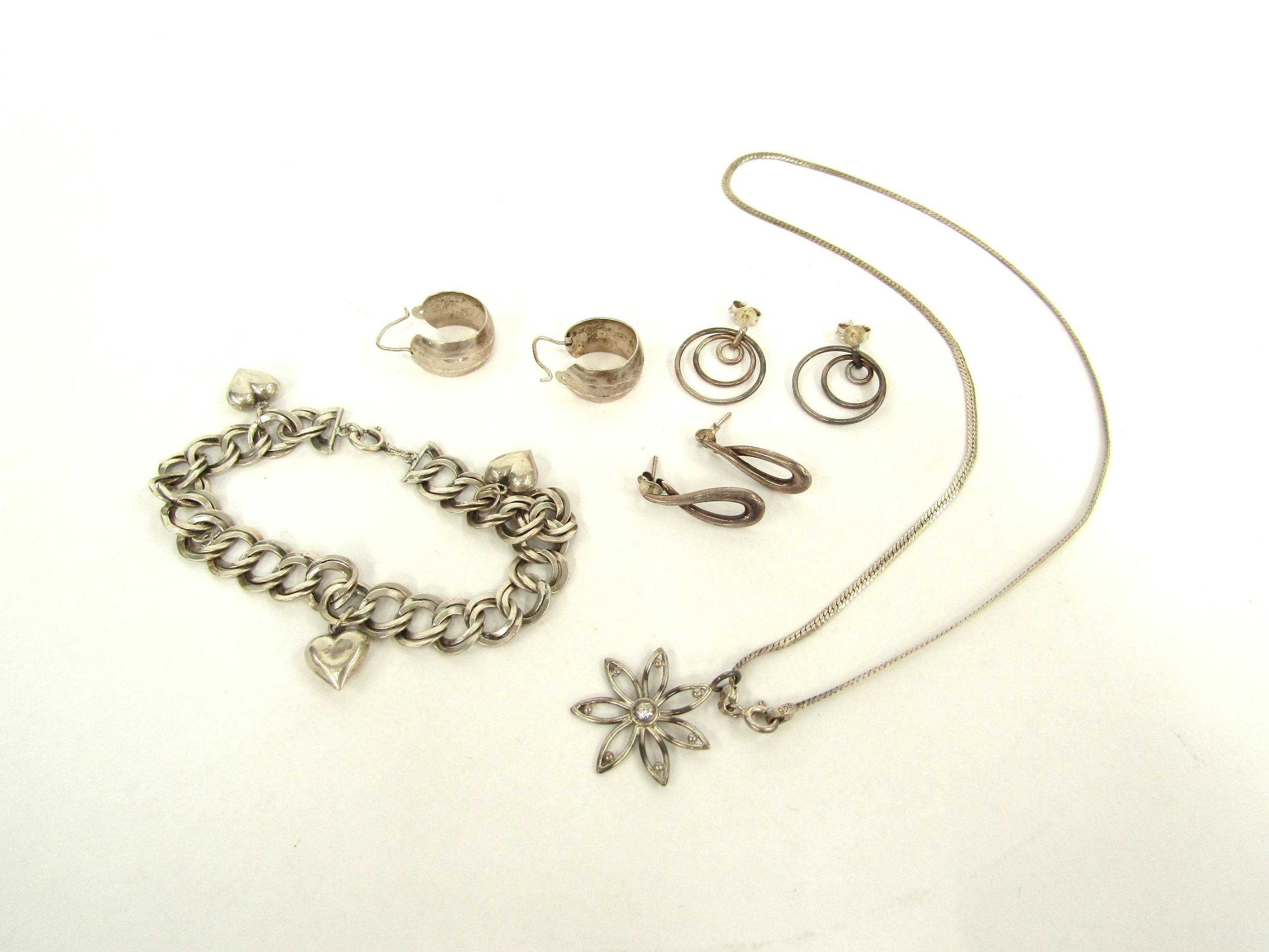 Silver necklace hung with floral pendant, sterling silver heart charm bracelet and three pairs of
