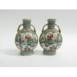 A pair of Oriental moon flasks depicting figures in exterior scenes, handles to shoulders, four