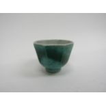 A Celadon green facet tea bowl with seal mark to base, hairlined