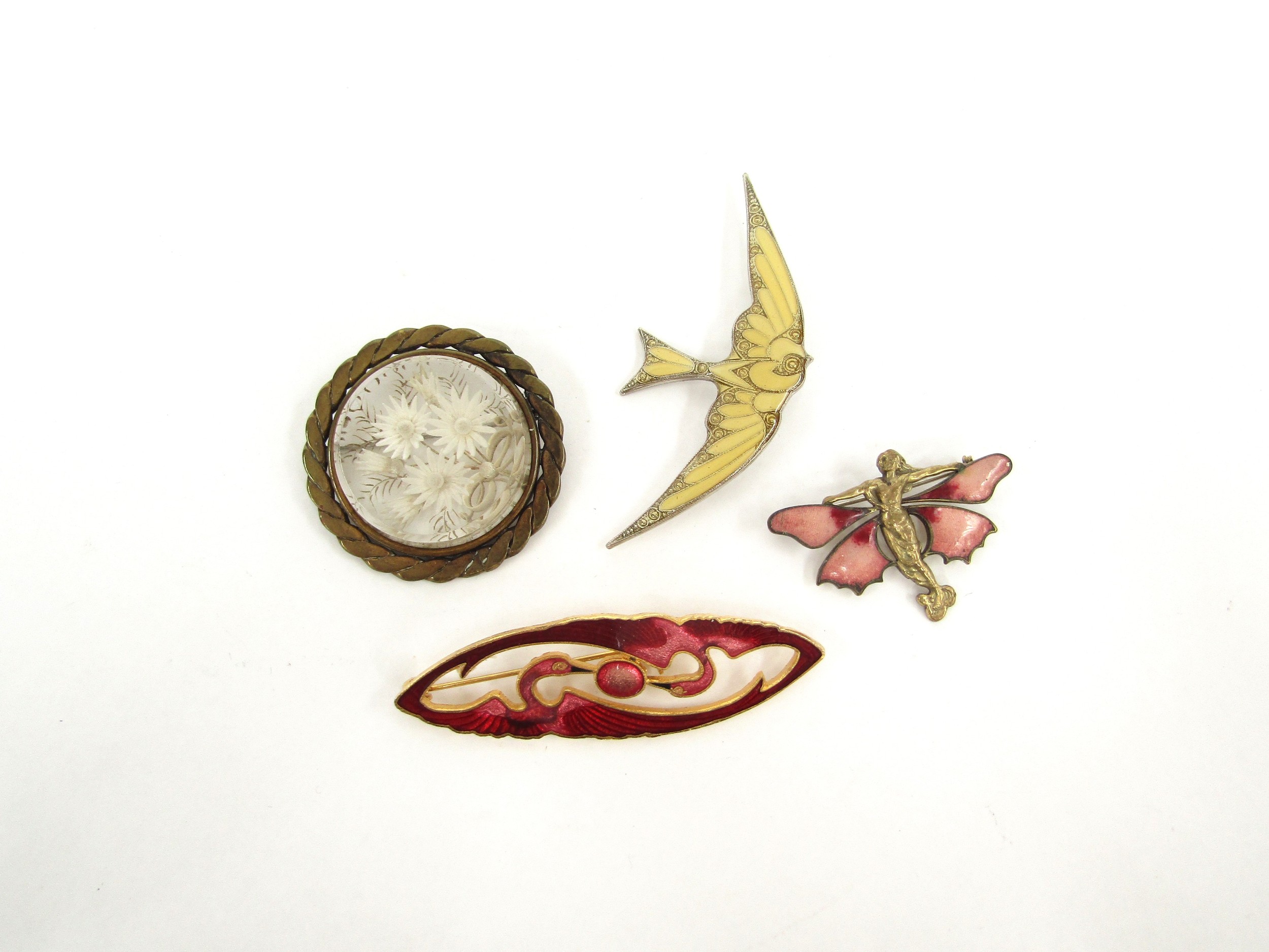 Four decorative brooches including fairy, swallow, flamingo and floral