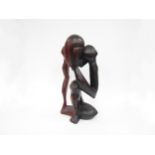 A modernist carved hardwood sculpture of a man with head in hands (split), 45cm tall