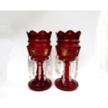 A pair of Victorian cranberry glass table lustres, overlaid detail, with crystal droplets, 38cm tall