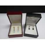 Two pairs of 9ct gold drop earrings including facet cut blue drops and sapphire examples, 1.6g