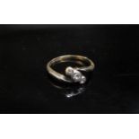 A three stone diamond crossover ring stamped 18ct/plat. Size K/L, 1.6g