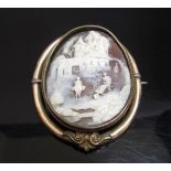 An oval carved shell cameo brooch depicting a man on mule, man pushing cart and female under