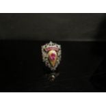 A shield form ring set with rubies and diamond chips, shank marked K18. Size O, 9.5g