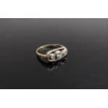 A gold ring set with three diamonds in halo. Size G, unmarked repair present, 1.9g
