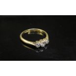An 18ct gold platinum set three stone diamond ring in rubover setting. Size M/N, 2.3g