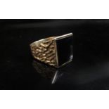 A 9ct gold signet ring, onyx front, textured shoulders. Size V, 7.2g