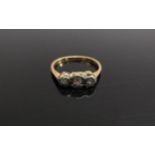 An unmarked gold three stone diamond ring. Size K/L, 2g