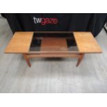 A teak coffee table with a smoked glass inset panel to top, undertier shelf, 136cm long x 51cm x