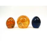 Three Shatterline paperweights in yellow, orange and blue. Largest 8cm high