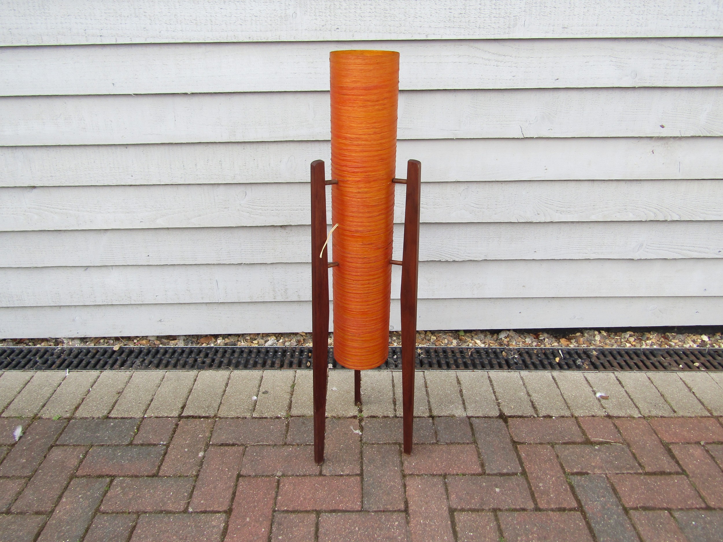 A 1960's orange fibreglass rocket lamp on three teak legs.