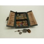 A leather slim jewellery box with vintage bijouterie contents including brooches, silver ingot,