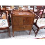 A George III mahogany nightstand, the gallery top with fret handles over a two door cupboard and