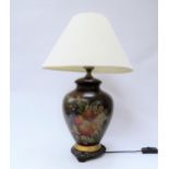 A bulbous form table lamp painted with fruits and flowers, with shade
