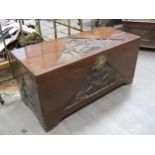 A Mid 20th Century Oriental camphor wood chest with carved tiger, tree and house detail to top,