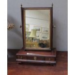 A George III mahogany toilet mirror with gilt relief the brass finials over a three drawer base on