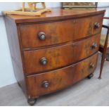 A 19th Century mahogany bow-front chest of three long drawers with mother-of-pearl roundels to