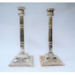 A pair of silver plated column form candlesticks on embossed ribbon and swag design bases, 32cm high