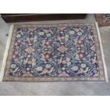 A 20th Century handwoven Persian rug. The central field decorated with floral lozenges with bird