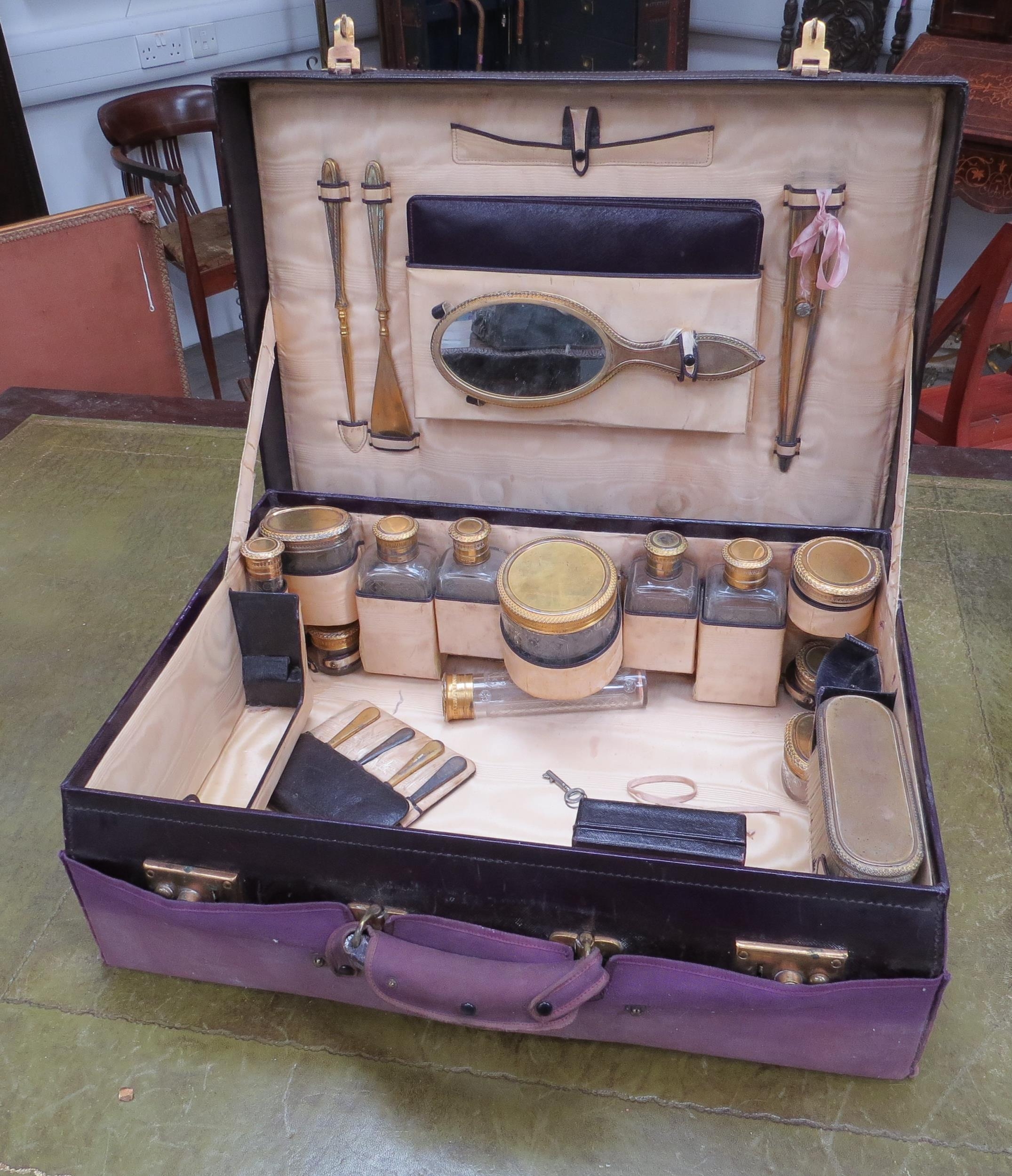 A red leather travelling/dressing case with fitted silk lined interior. The contents including 12