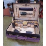 A red leather travelling/dressing case with fitted silk lined interior. The contents including 12
