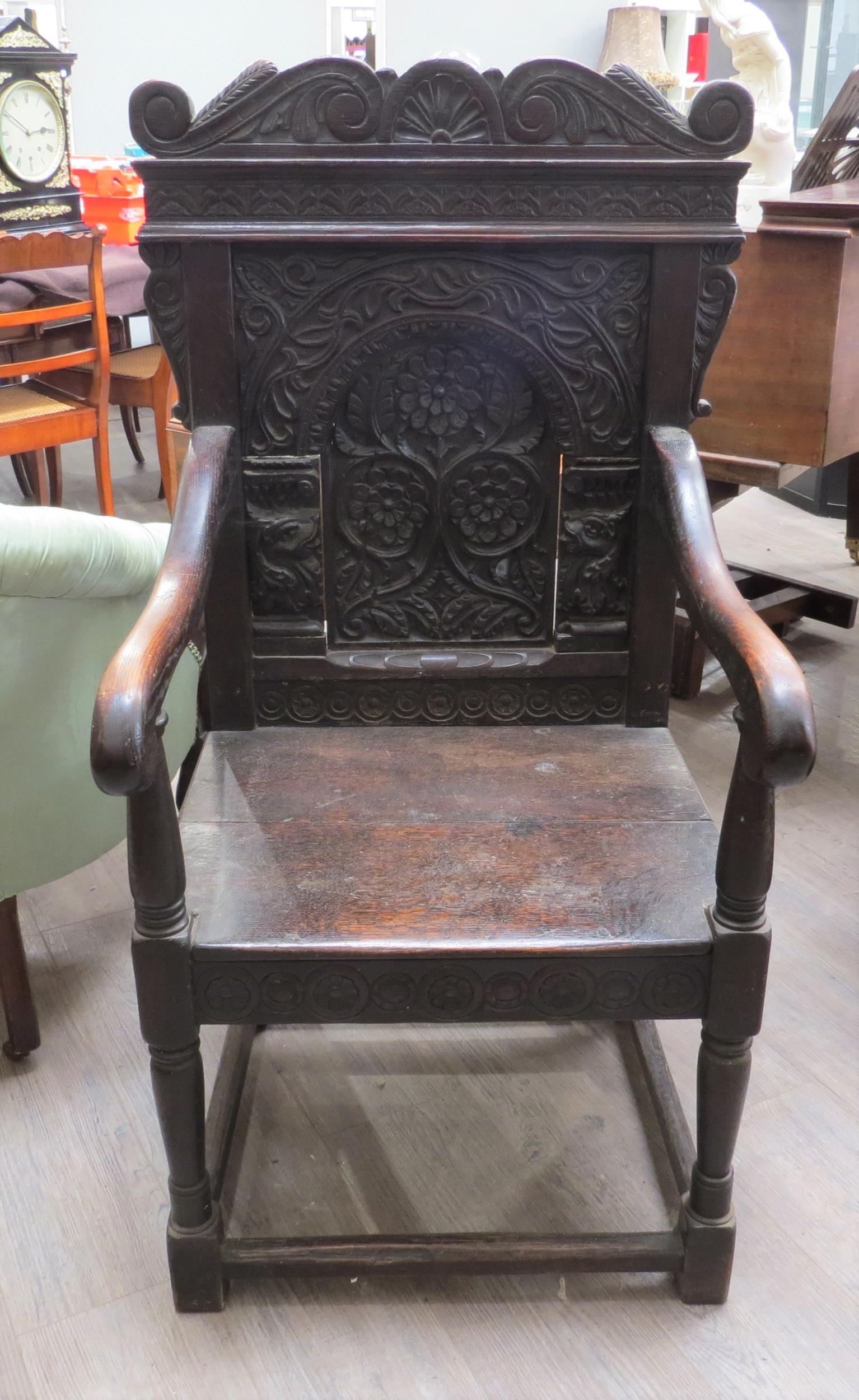 A 17th Century and later Wainscot chair with scroll top and dragon detail, vine, leaf and flower