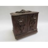 A black forest smokers cabinet applied with leaves and flowers in high relief rising lid to top,