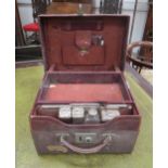 A gentleman's red leather vanity case with part contents including three silver lidded containers by