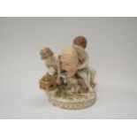 A late 19th Century Meissen porcelain figural group of two putti with an oversized theatrical mask