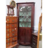 Circa 1800 a line inlaid mahogany astragal glazed single door cabinet over a two door cupboard on