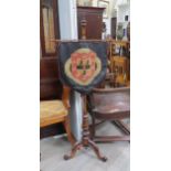 A Victorian walnut pole screen, brass bar holding an embroidered shield coat of arms, 137cm high x