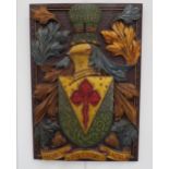 A carved heraldic panel with painted gilded detail, 64cm x 44cm