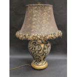 A brown and gilt ceramic baluster form table lamp with frilled shade, 64cm tall